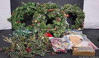Group shot of wreaths, lights, foliage picks and ornament containers