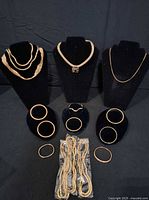 Group view of all necklaces and bracelets displayed on stands and packaged pieces