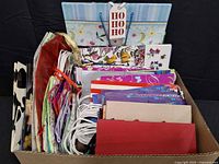 Full view of cardboard box showing variety and quantity of gift bags