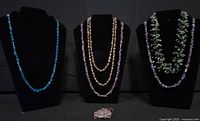 All jewellery pieces displayed: three necklace stands showing six stone-chip necklaces and wire-wrapped amethyst pendant on table