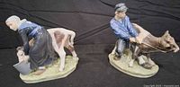 Front view of both Royal Copenhagen figurines showing girl with calf and boy pulling calf