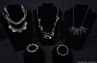 Group shot showing all four necklaces on busts and two bracelets on stands