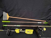 All items laid out: broom, two wooden-handled tools, Ryobi trimmer body