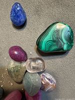 Group of polished gemstones showing color variety and malachite piece