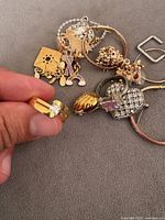Group of assorted jewellery pieces with ring held in hand