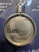 Front view of Rick Hansen 25 Years medal showing design and text