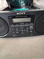 Front view of Sony ZS-RS60BT showing display, speakers, controls, USB port