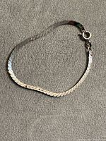 Full view of stainless steel herringbone bracelet laid flat