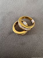 Two gold plated sterling silver rings stacked on fabric showing stones