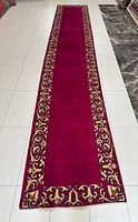 Full view of magenta Kashan runner rug showing entire length and border design