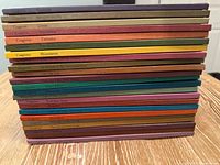 Stack of 23 hardcover Serendipity books showing coloured spines