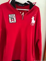 Front of red Ralph Lauren quarter-zip sweater with Canada patch and Polo logo