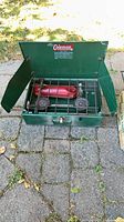 Open Coleman Model 421 camp stove showing burners and red fuel tank