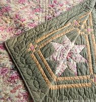 Quilt showing star patchwork side with reverse floral side folded back