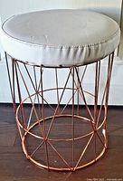 Full view of copper tone wire frame vanity stool with white seat