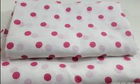 Folded curtain panels showing polka-dot pattern