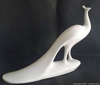 Full side view of porcelain peacock showing entire form