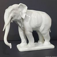 Right side view of white porcelain elephant on base