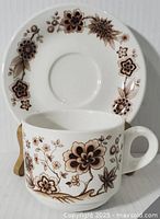 Front view of mug and saucer showing floral pattern