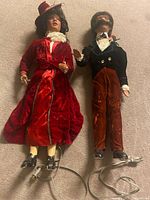 Full view of both dolls lying flat with power cords visible
