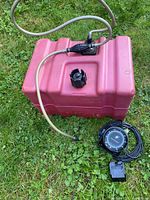 Red plastic fuel tank with hose, primer bulb and compass beside it