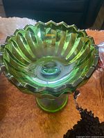 Top view of green carnival glass compote showing ribbed bowl and scalloped rim
