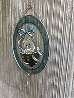 Full view of oval cat glass wall hanging on vertical surface