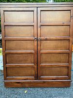 Front view of closed wooden bar cabinet showing paneled doors