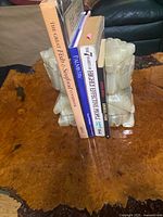 Pair of pale green carved stone bookends holding books