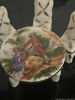 Top of round dining table showing painted courting scene