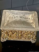 Top view showing embossed "Best Wishes" lid and ornate border