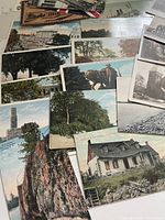 Spread of colour-tinted and monochrome postcards showing buildings, landscapes, monument and elephant rider.