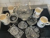 Group shot of all glass pieces and four ceramic steins