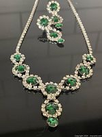 Full view of necklace and earrings laid flat