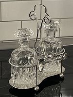 Full view of Sheffield silver cruet stand with two cut crystal decanters and stoppers on stove surface