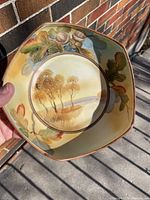 Top view of hand painted Nippon bowl showing landscape scene and acorn moriage