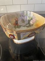 Exterior view showing pedestal base, raised enamel decoration and overall form