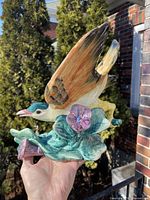 Left side view of glazed Stangl bird figurine showing wing detail and foliage base