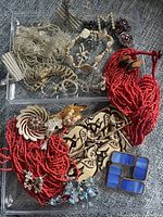 Overview of full tray showing necklaces, brooches, earrings, bracelet and blue glass link piece