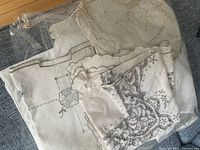 Stack of embroidered linen pieces inside plastic bag