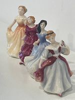 Front angled view of all four figurines in line