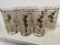 Six frosted highball glasses with gold pinecone design