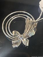Front view of sterling brooch showing triple rings and bow