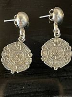 Full view of both sterling silver drop earrings with Aztec design