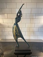 Full view of metal figure sculpture on stand