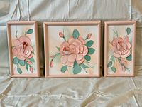 Three peach/pink floral paintings with peach frames