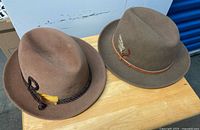Two felt fedora hats side by side on table