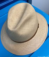 Overhead view of woven straw fedora with hatband