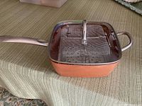 Pot with lid on showing square shape and handles