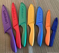 Six Cuisinart colour-coded knives with guards laid out